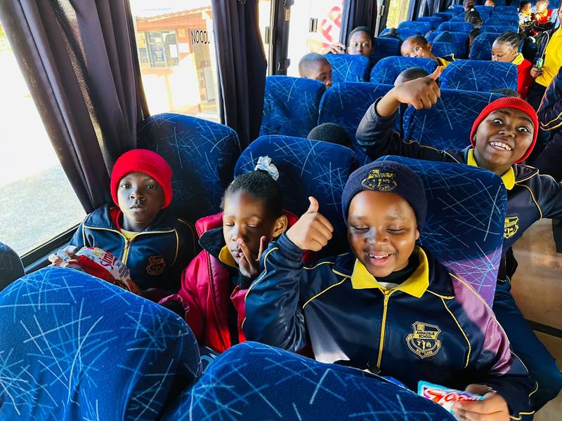 Pupils giving a thumbs up from their bus seats