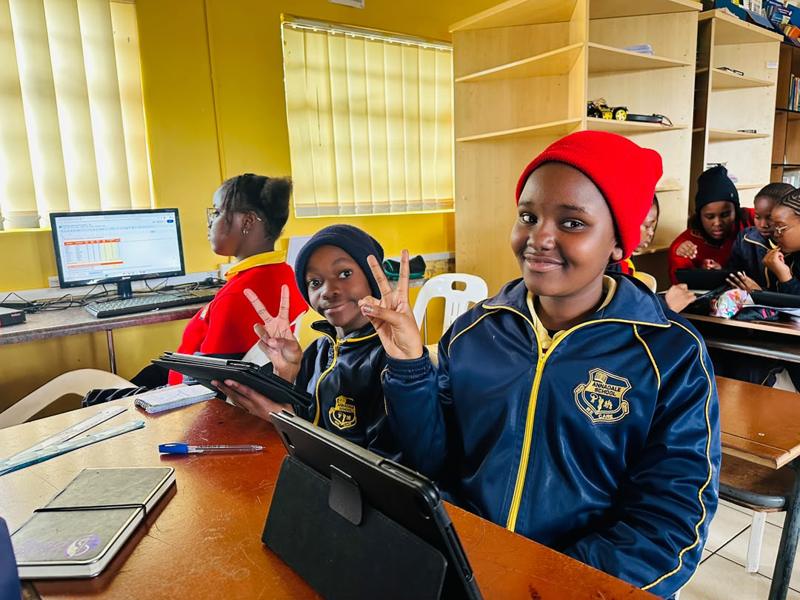 A group of pupils holding tablets in the ICT room