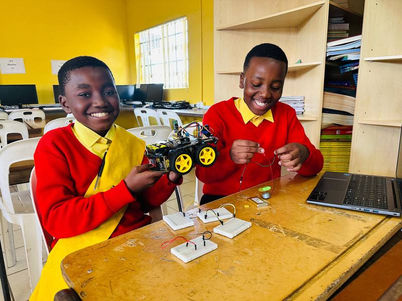 Pupils holding up a robot buggy they built